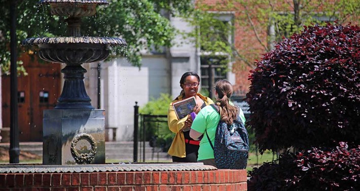 students talking at fountain